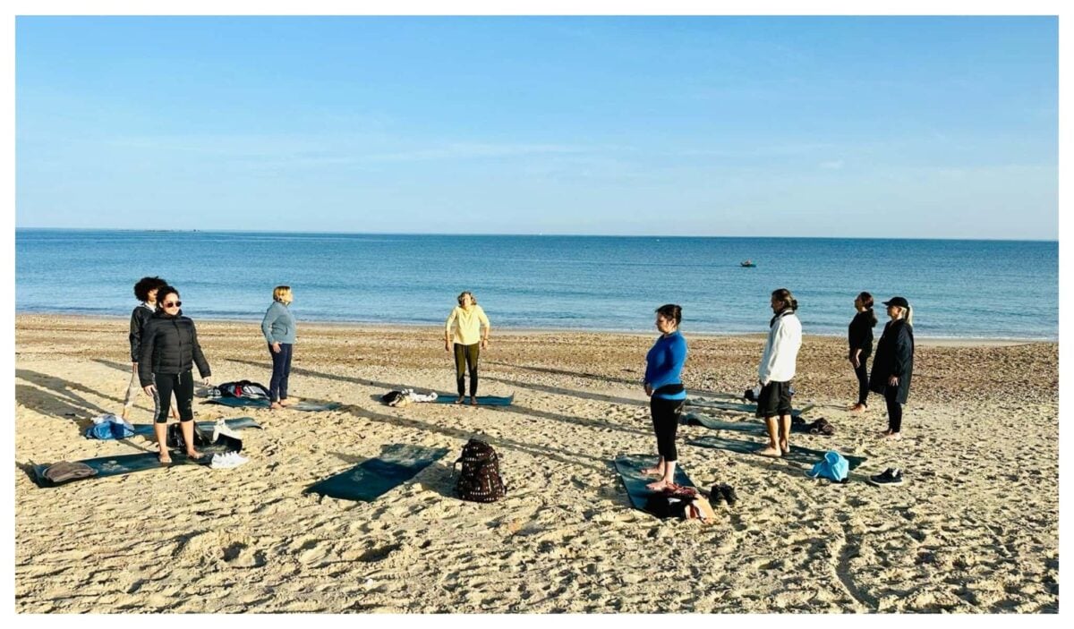 Retreat participants gathered in circle at a Normandy beach