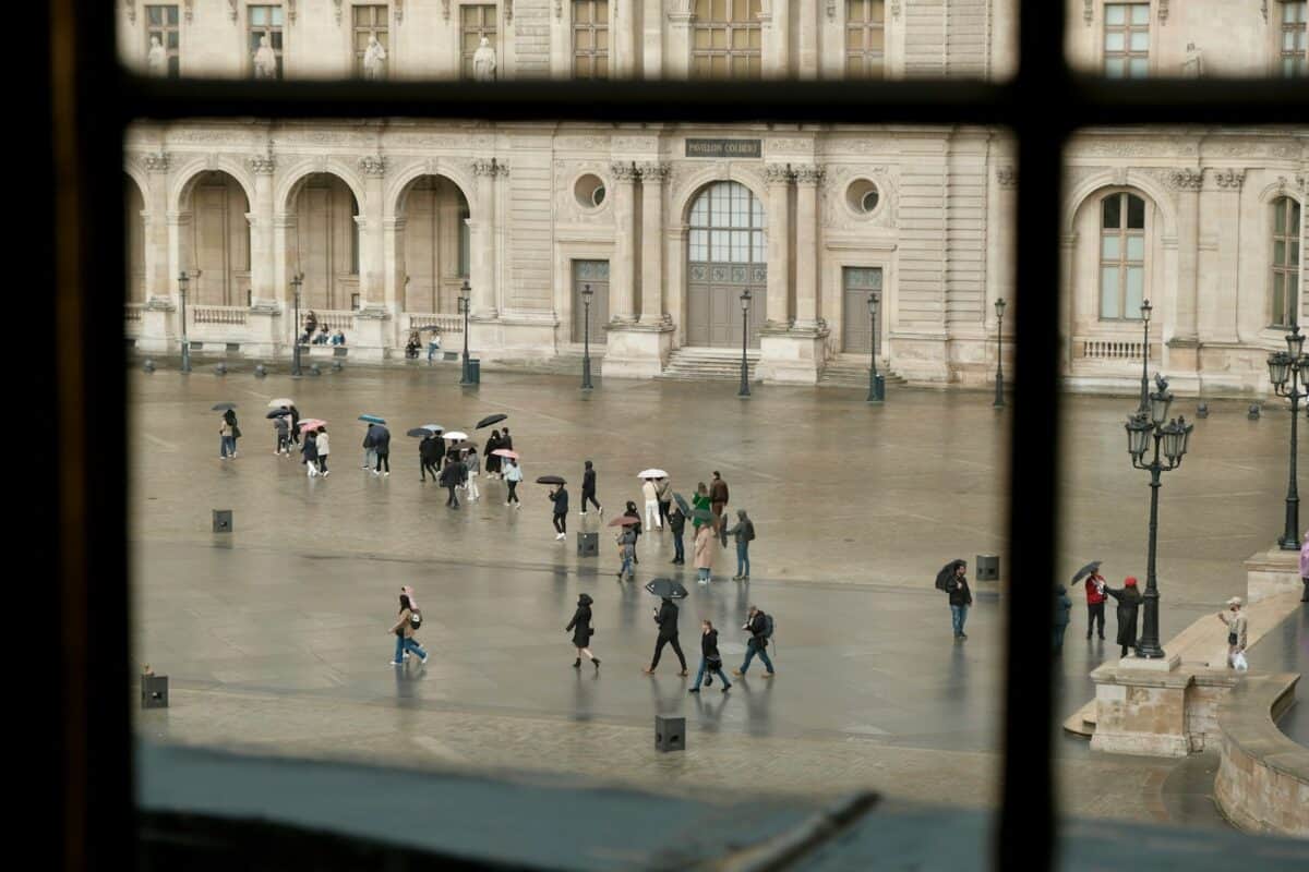 um grupo de pessoas andando por um pátio em Paris.
