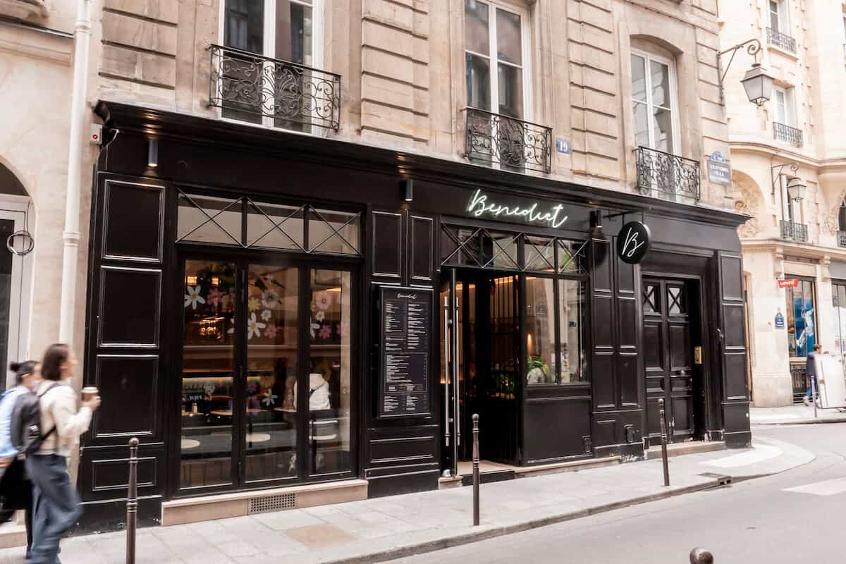 Benedict Restaurant in the Marais with a black exterior and neon sign.