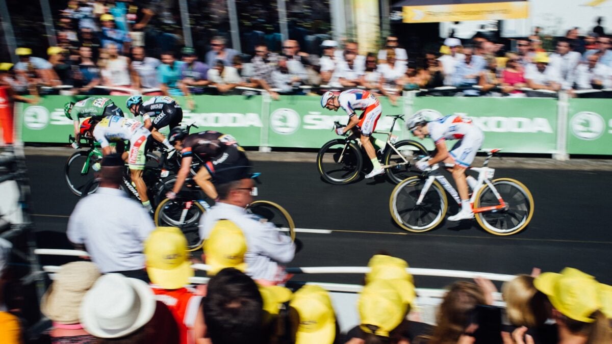 A group of people watching cyclist racing during the Tour de France.