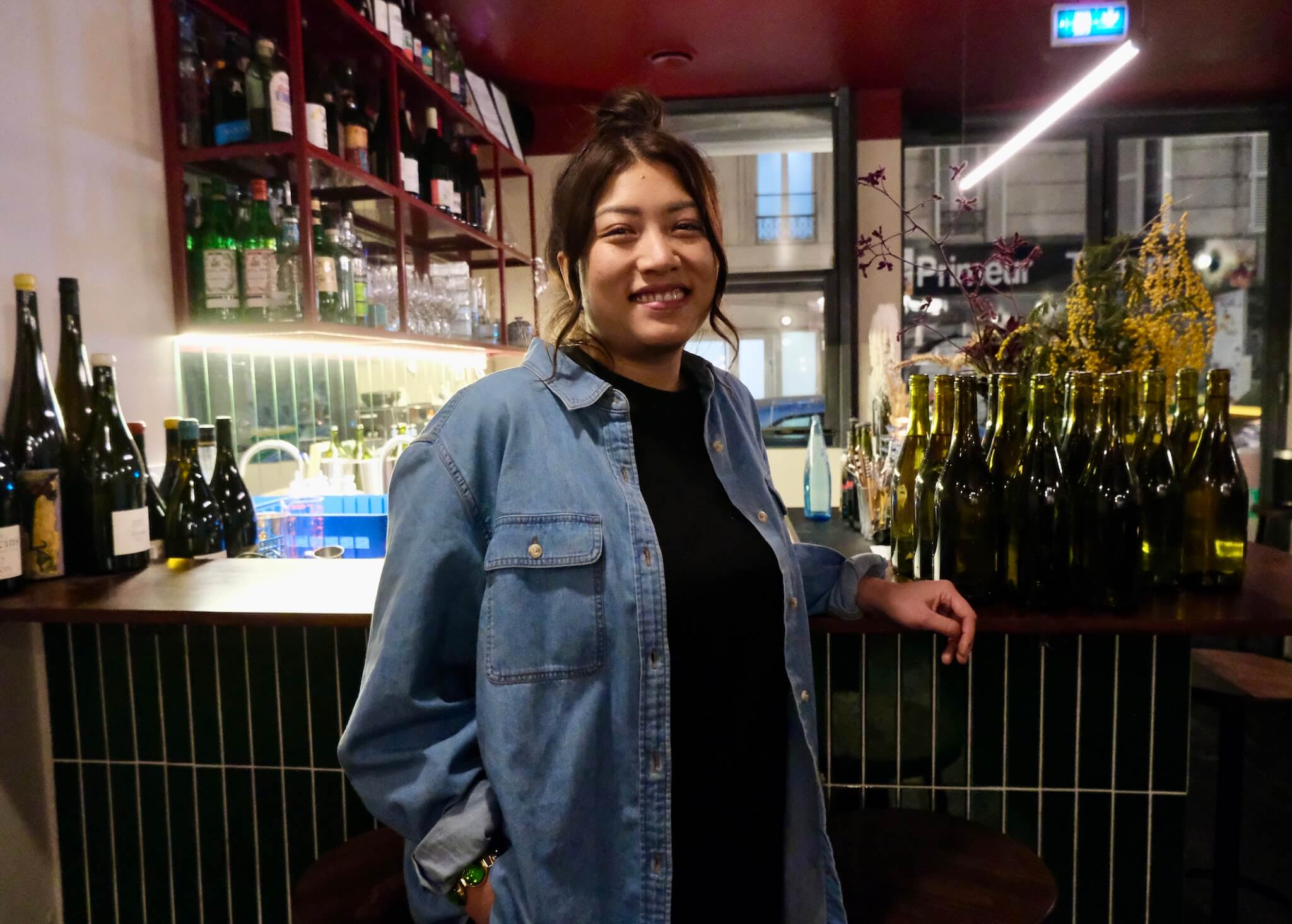 A photo of Priscilla Tram in front of the bar at Trâm130.