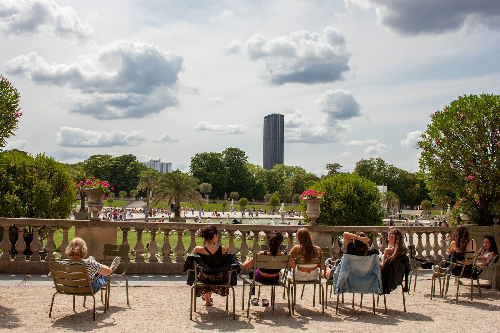a group of people sitting on chairs in a park.