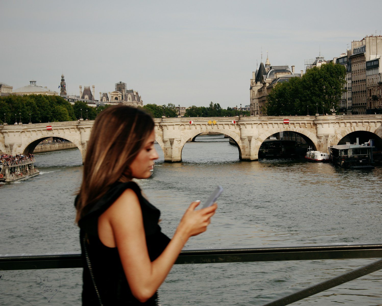 woman in black tank top standing near the seine during daytime.