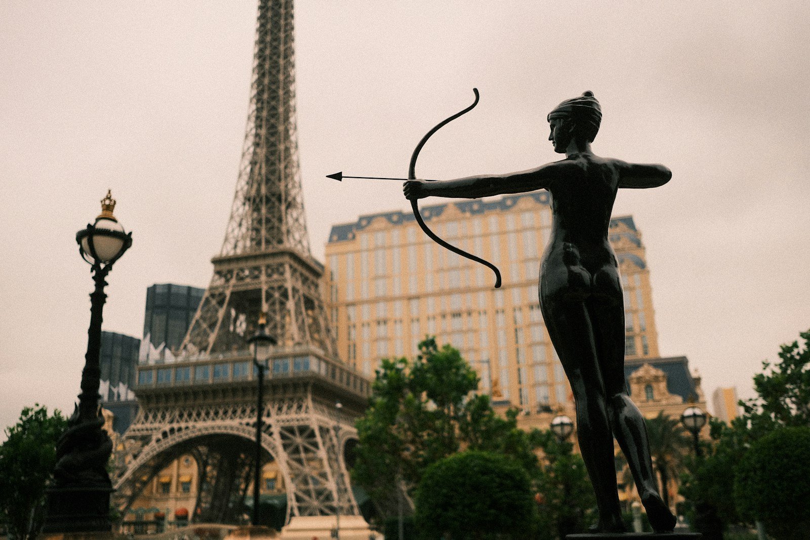 A statue of an archer with the eiffel tower.