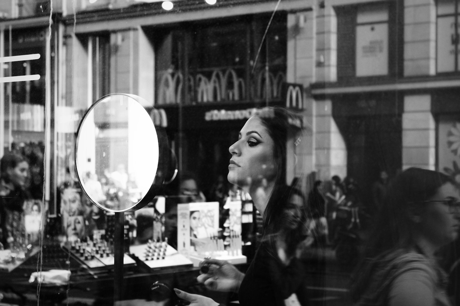woman in black long sleeve shirt standing near glass window.