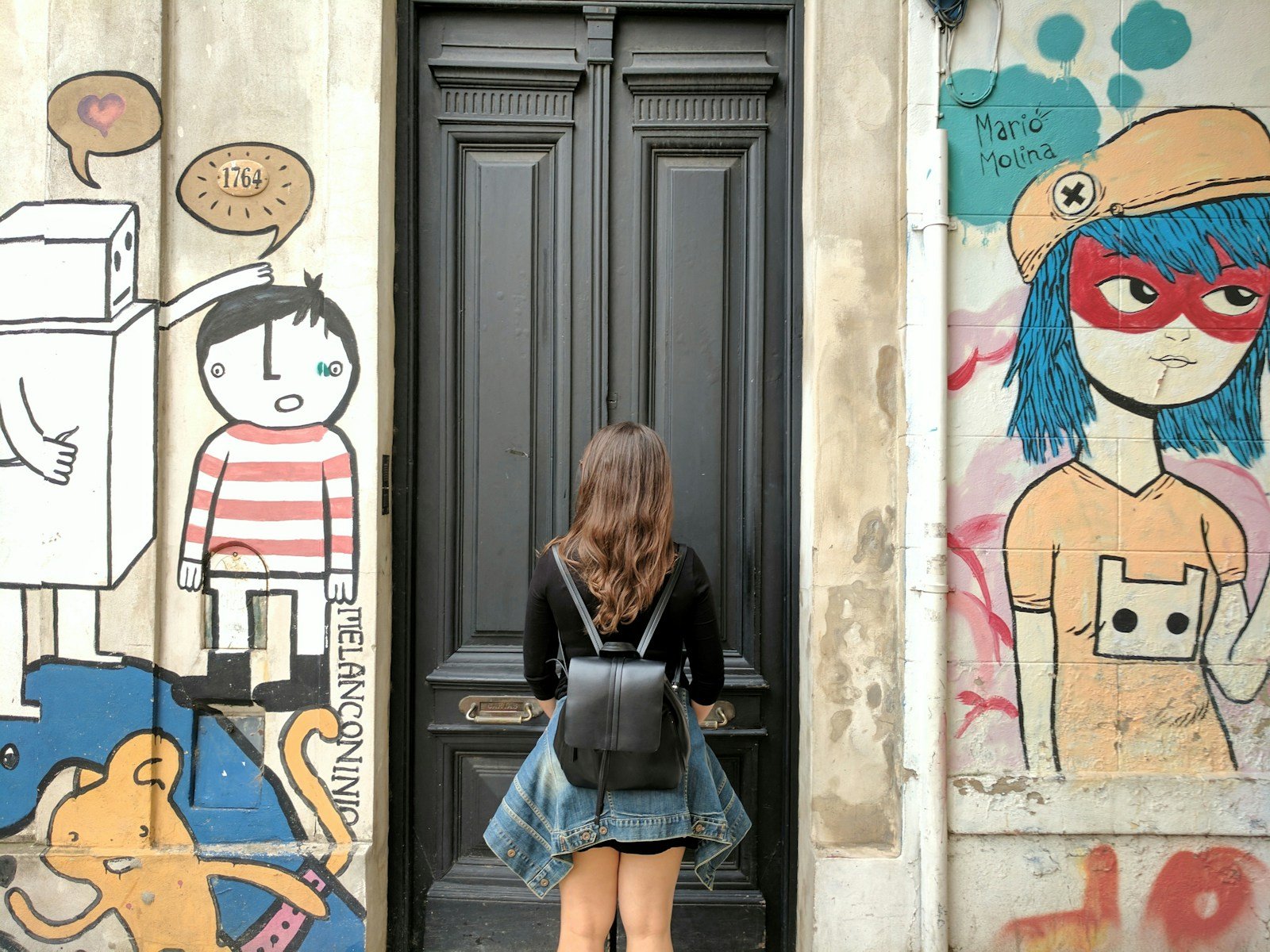 woman wearing black leather knapsack.