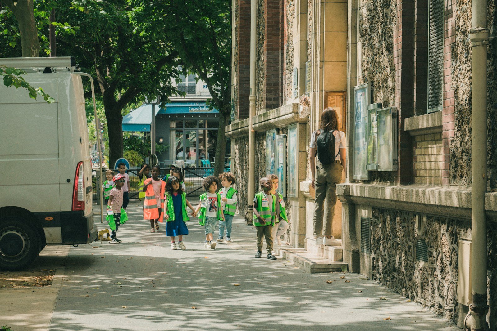 A group of children walking down a street next to a truck.