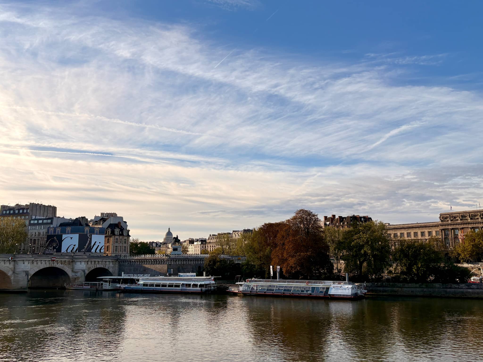 Seine and Pont Neuf view, boats and trees with fall colors.