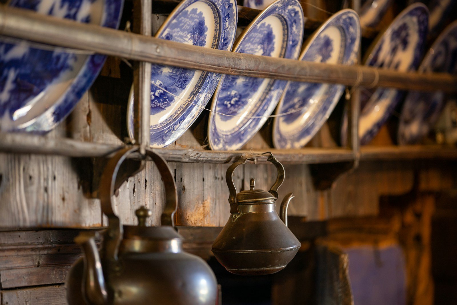 white and blue ceramic mugs on brown wooden rack.