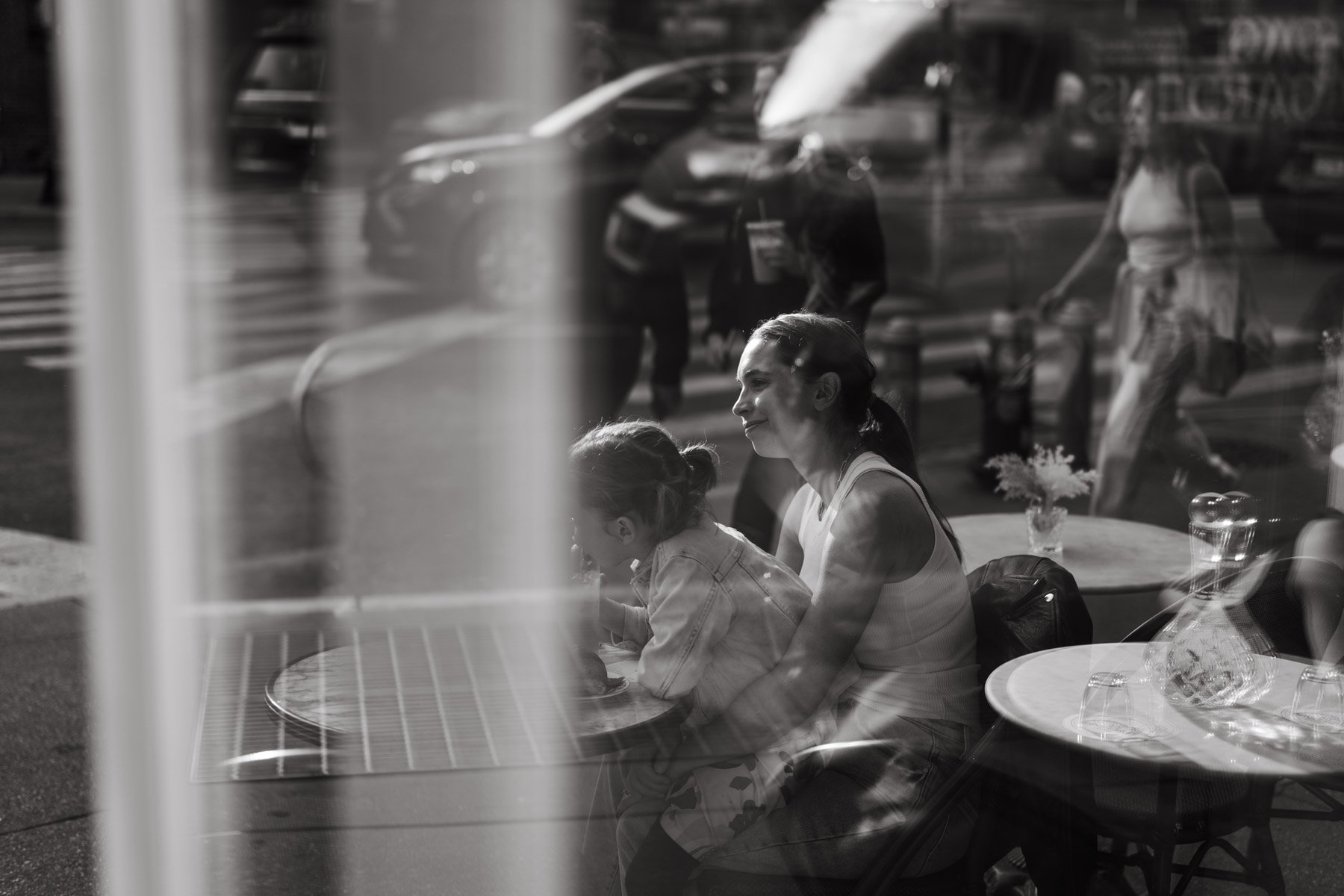 Katie Donnelly holding her young daughter on her lap at a Paris cafe.