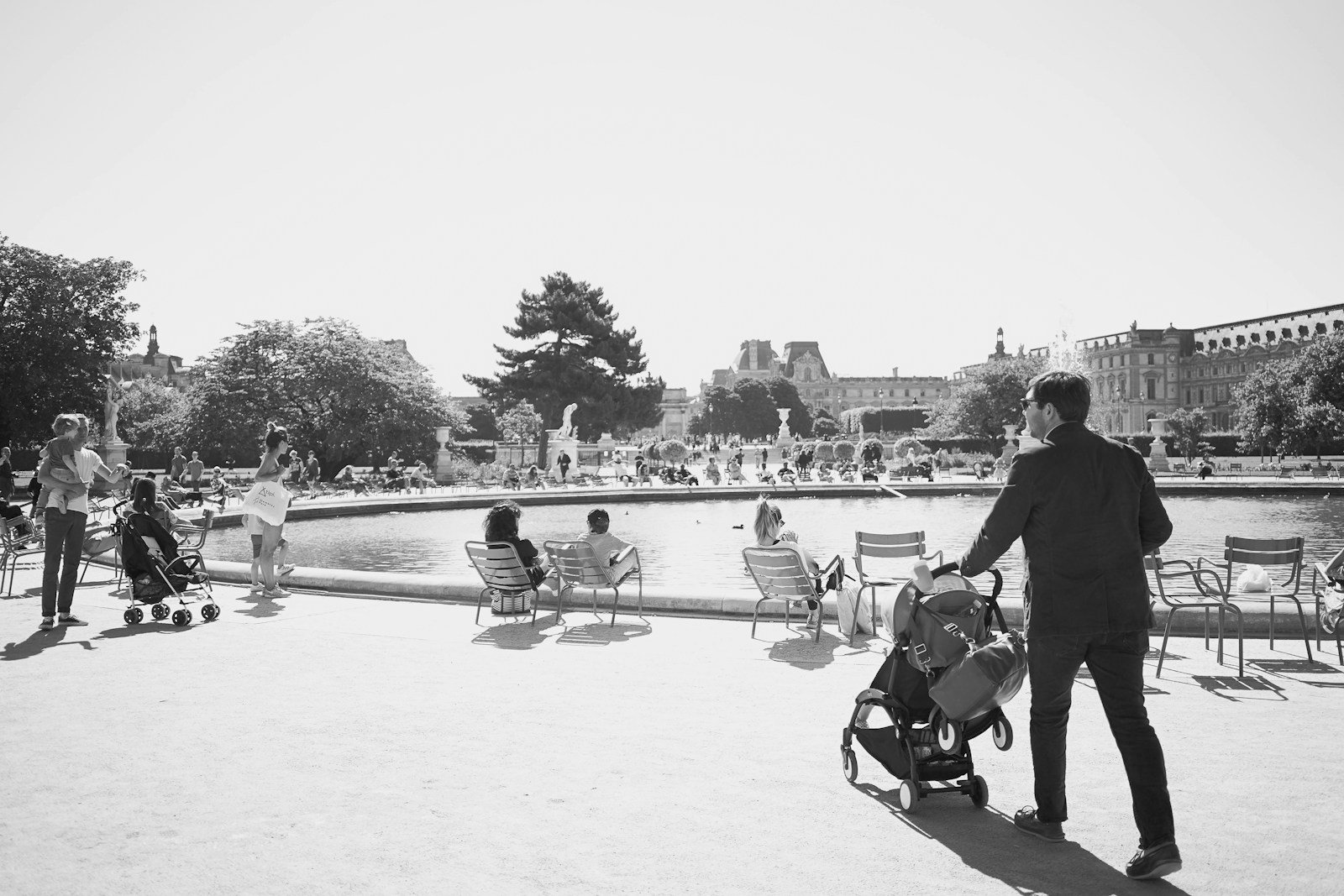 a group of people sitting on chairs by a lake.