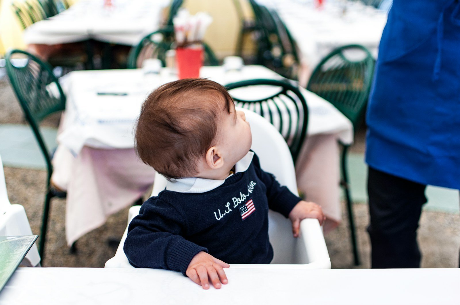 A baby sitting in a high chair at a table.