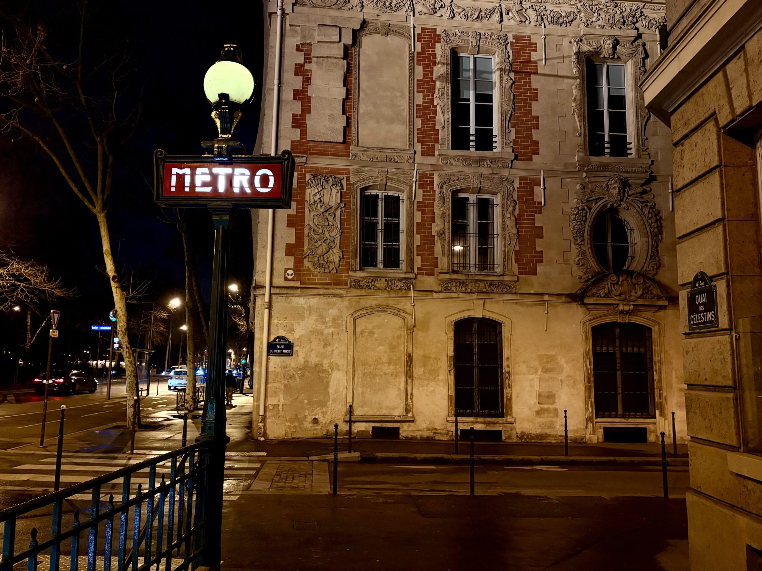 a Parisian building and metro station at night.