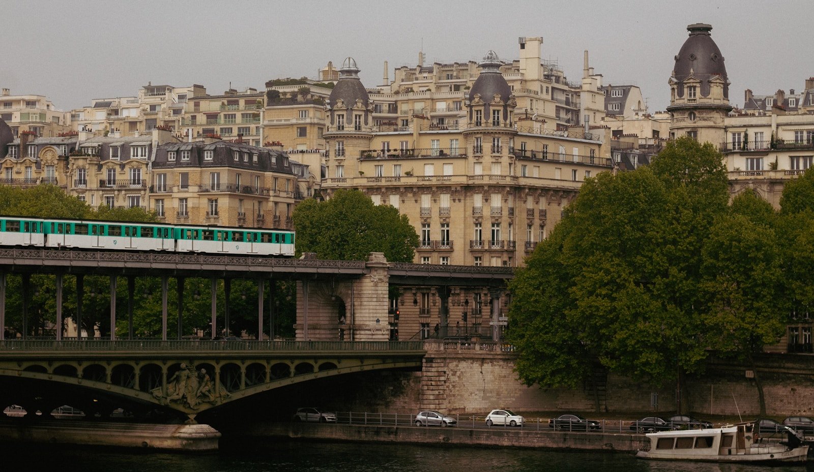 a green and white train traveling over a bridge