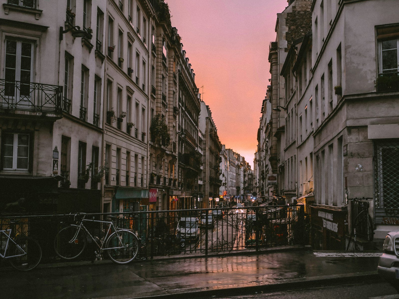 a Paris street filled with lots of tall buildings at dusk.