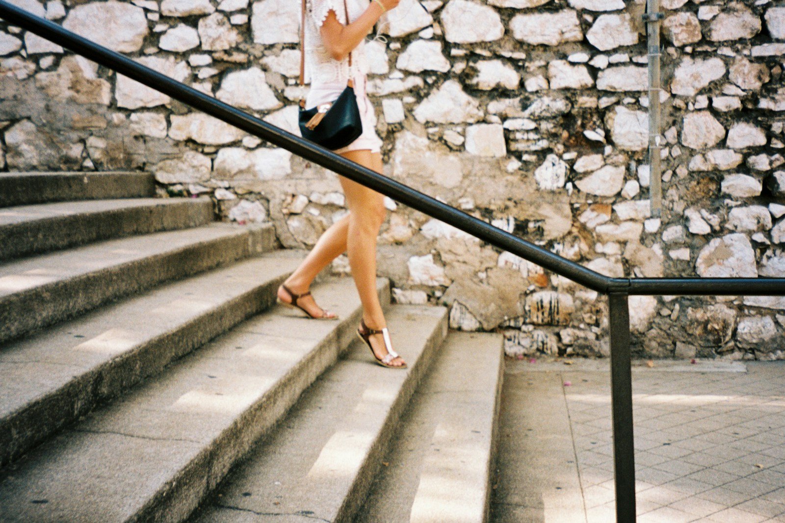 a woman is walking down a set of stairs.