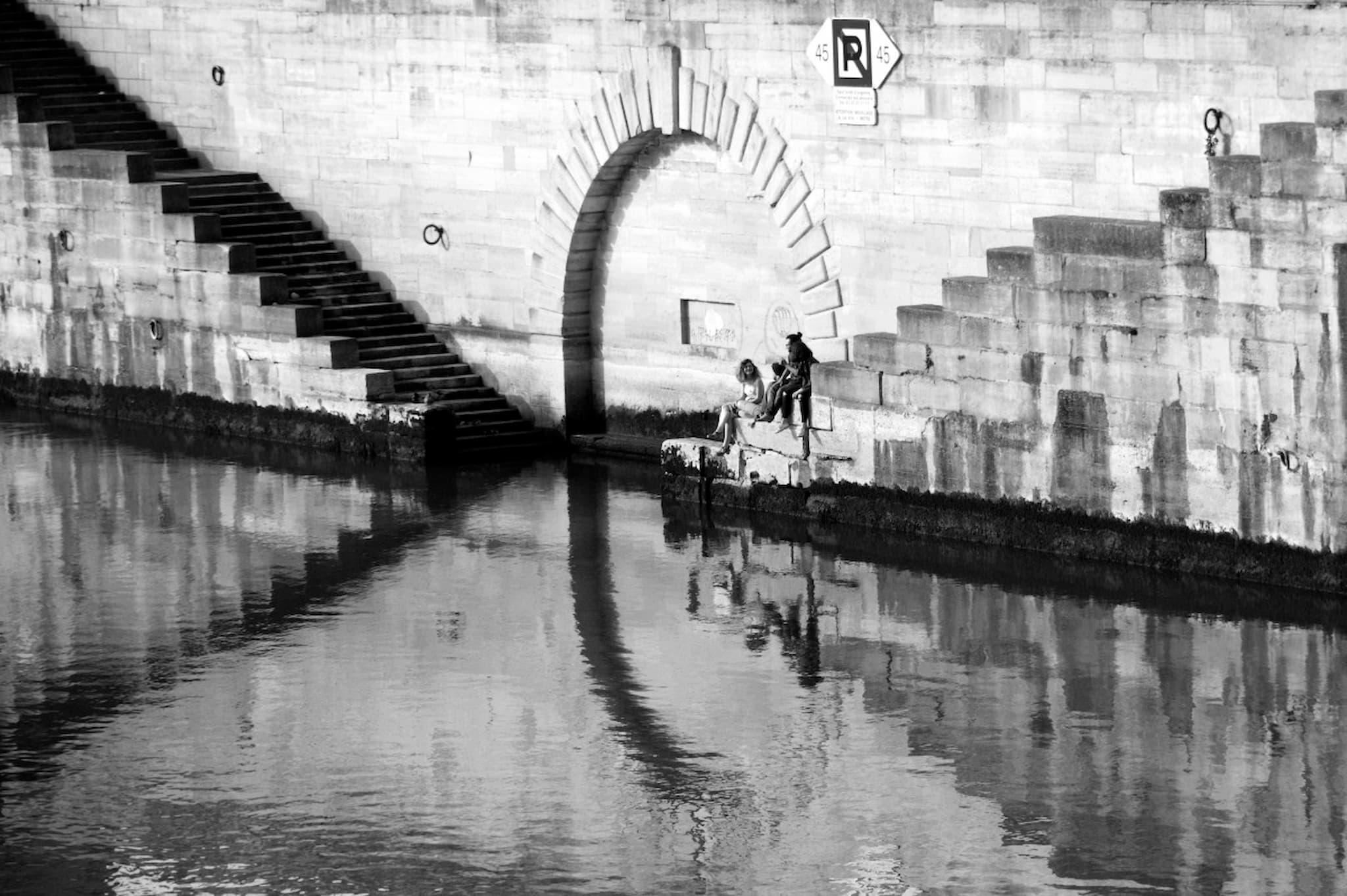 People sit on a staircase leading to the Seine in Paris
