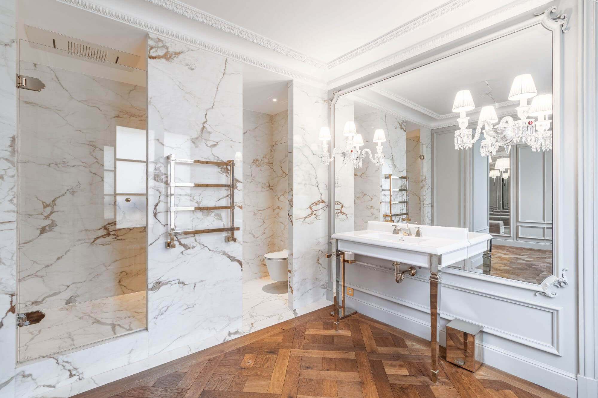 Paris apartment bathroom marble walls shower and sink parquet floor