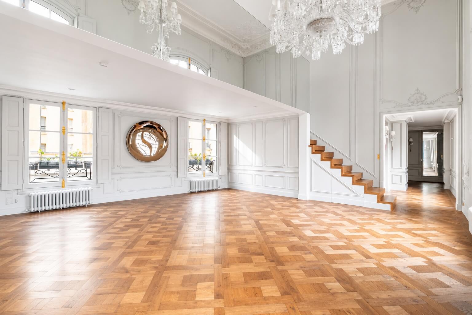 Place des Vosges Paris apartment open bright living room parquet floors staircase and chandelier