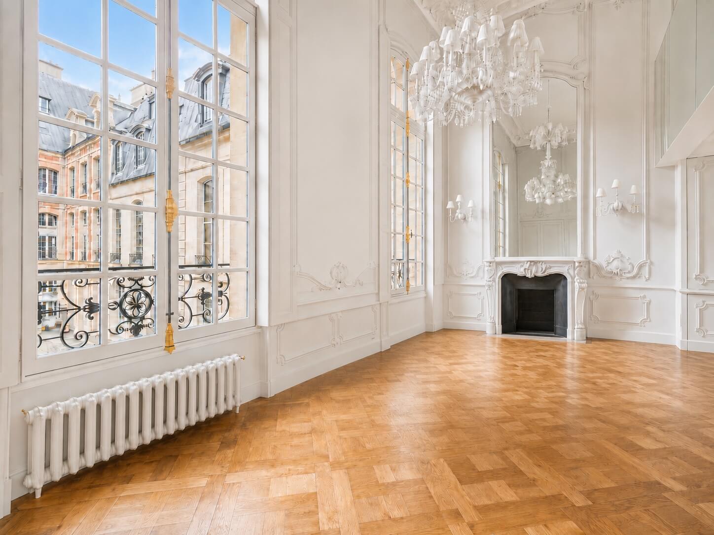 Place des Vosges Paris apartment window and chandelier parquet floors fireplace and mirror