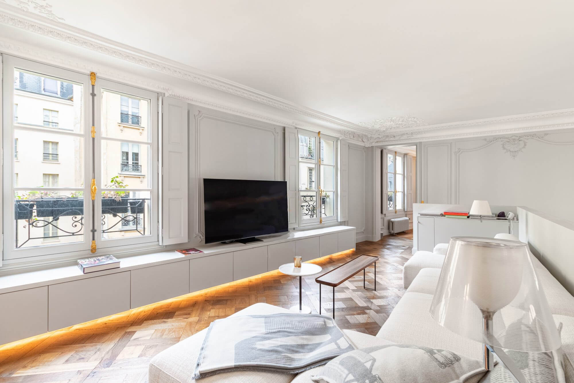 Paris apartment bright living room white couch parquet floors